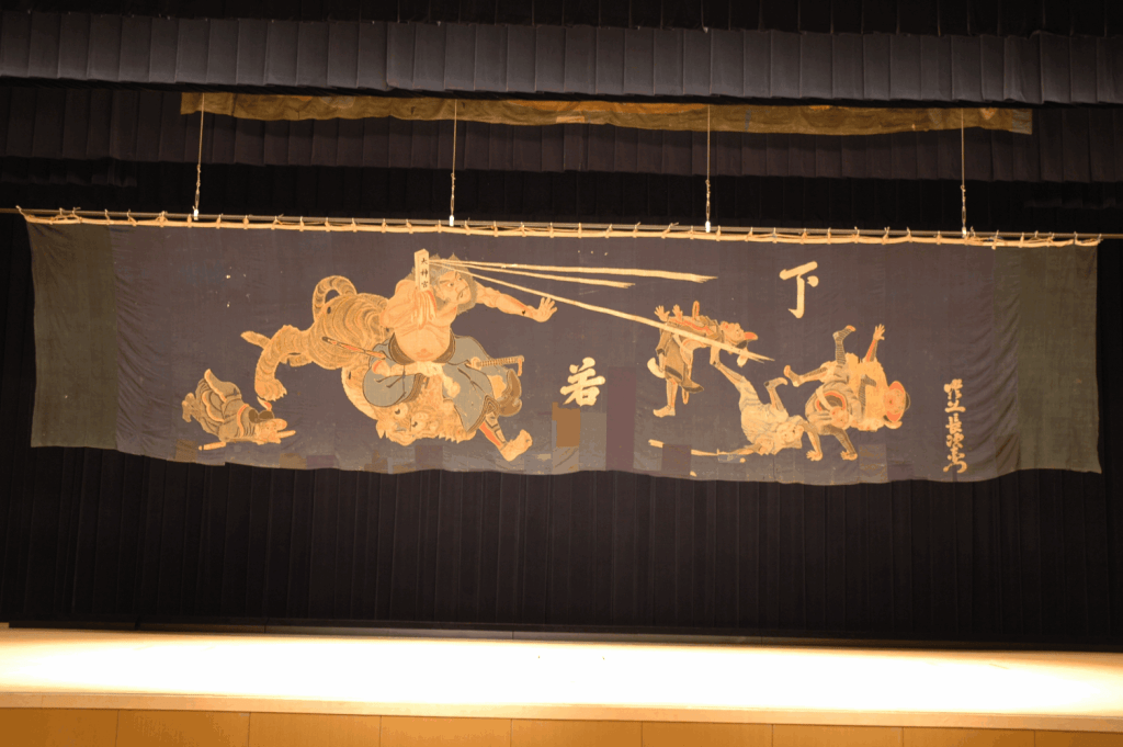 下小瀬の舞台の大幕。近松門左衛門作の浄瑠璃「国性爺合戦」の一場面を書いたもの。